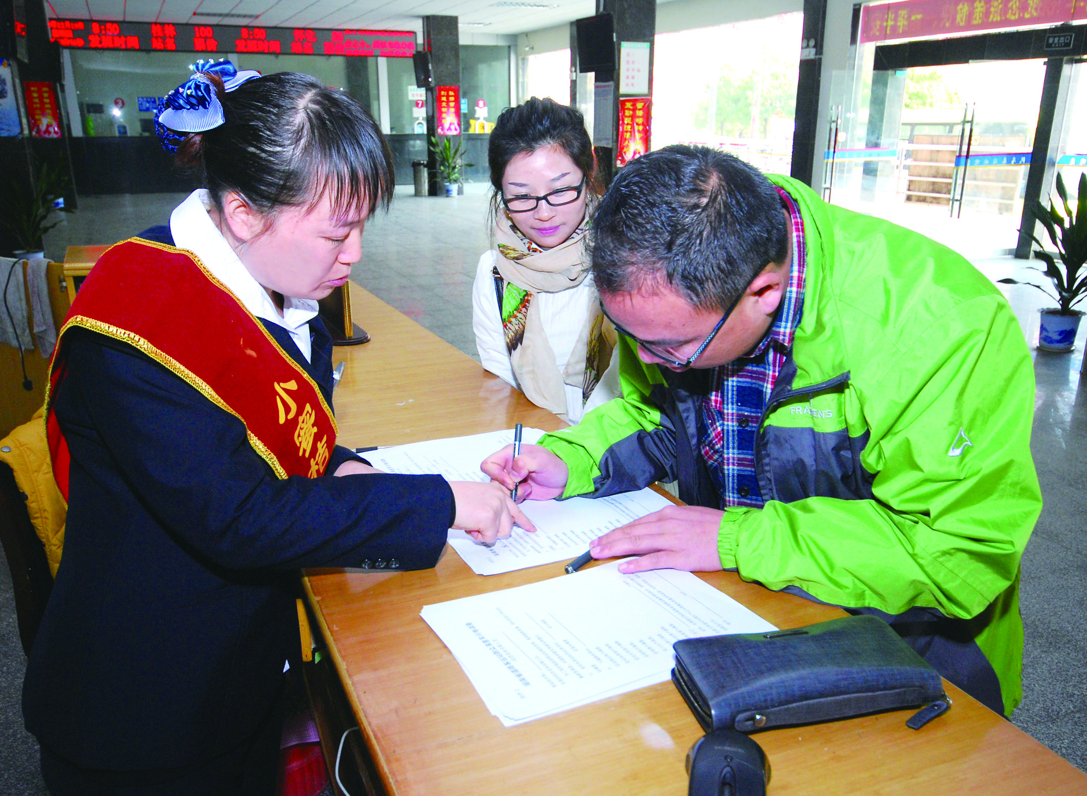 圖為洞口汽車總站站務(wù)人員在熱心為旅客服務(wù)。